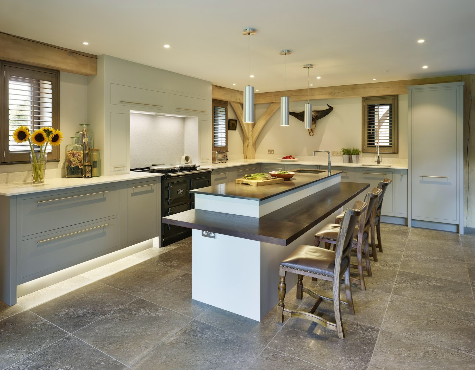 Kitchen island featuring integrated seating and grey kitchen cabinetry