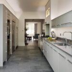 Long Linear kitchen featuring grey cabinetry and black worktops