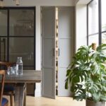 Grey Arbor kitchen pantry with door ajar revealing organised storage