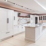 White Arbor kitchen cabinetry with white and pink marble worktops against pale pink walls