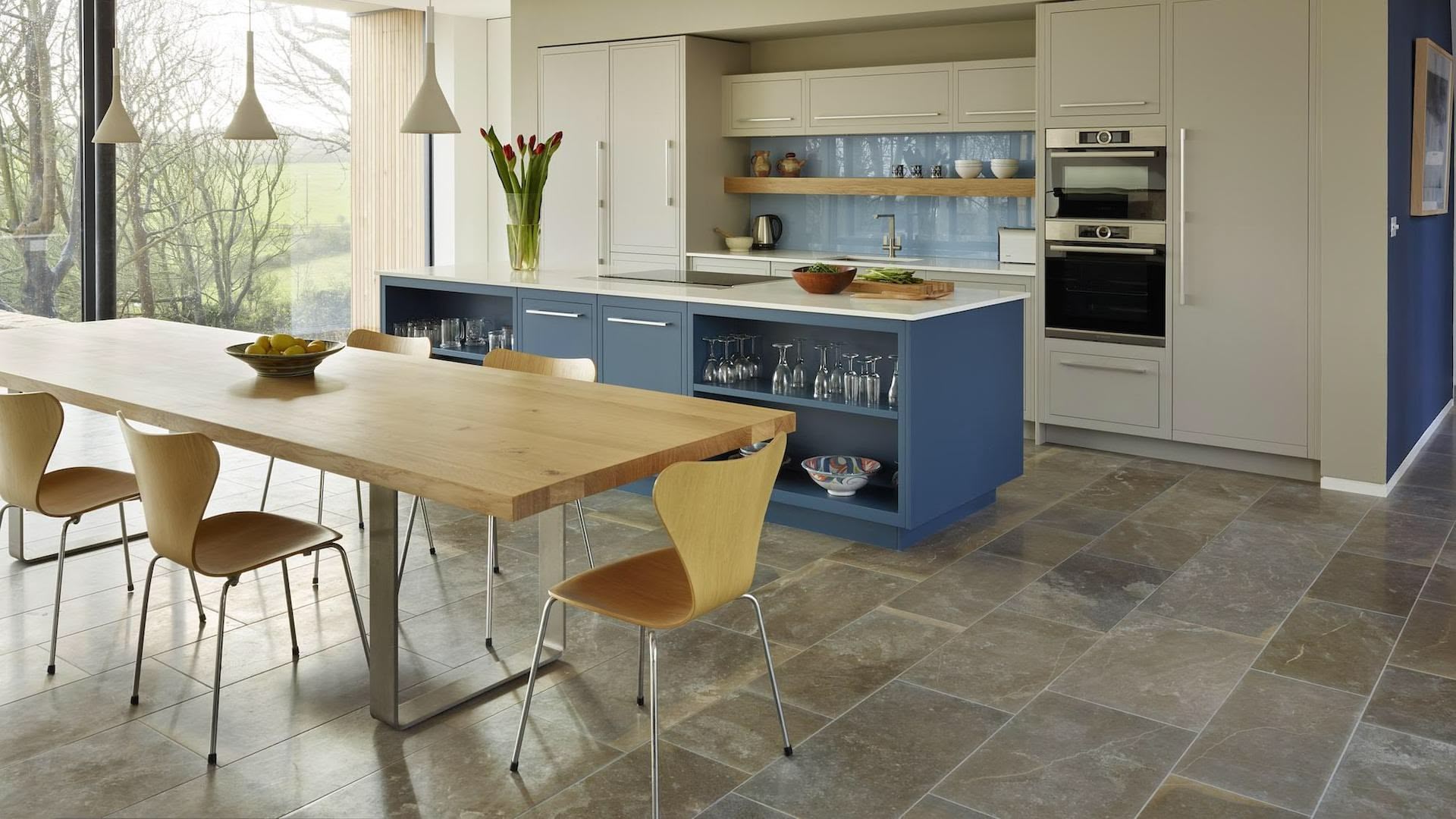 Open plan kitchen featuring blue kitchen island and dining area