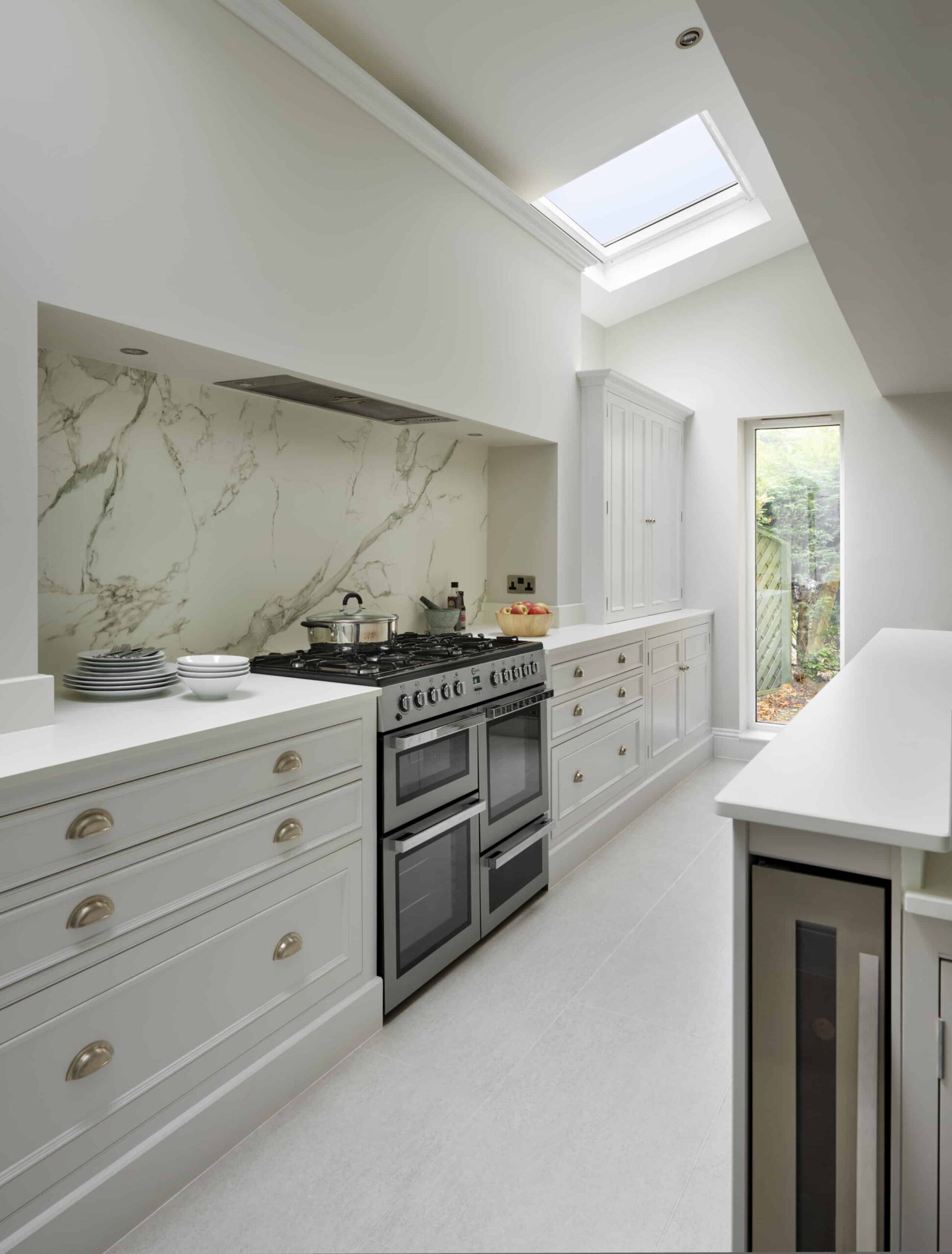 White Original kitchen cabinetry with marble splashback against the cooker