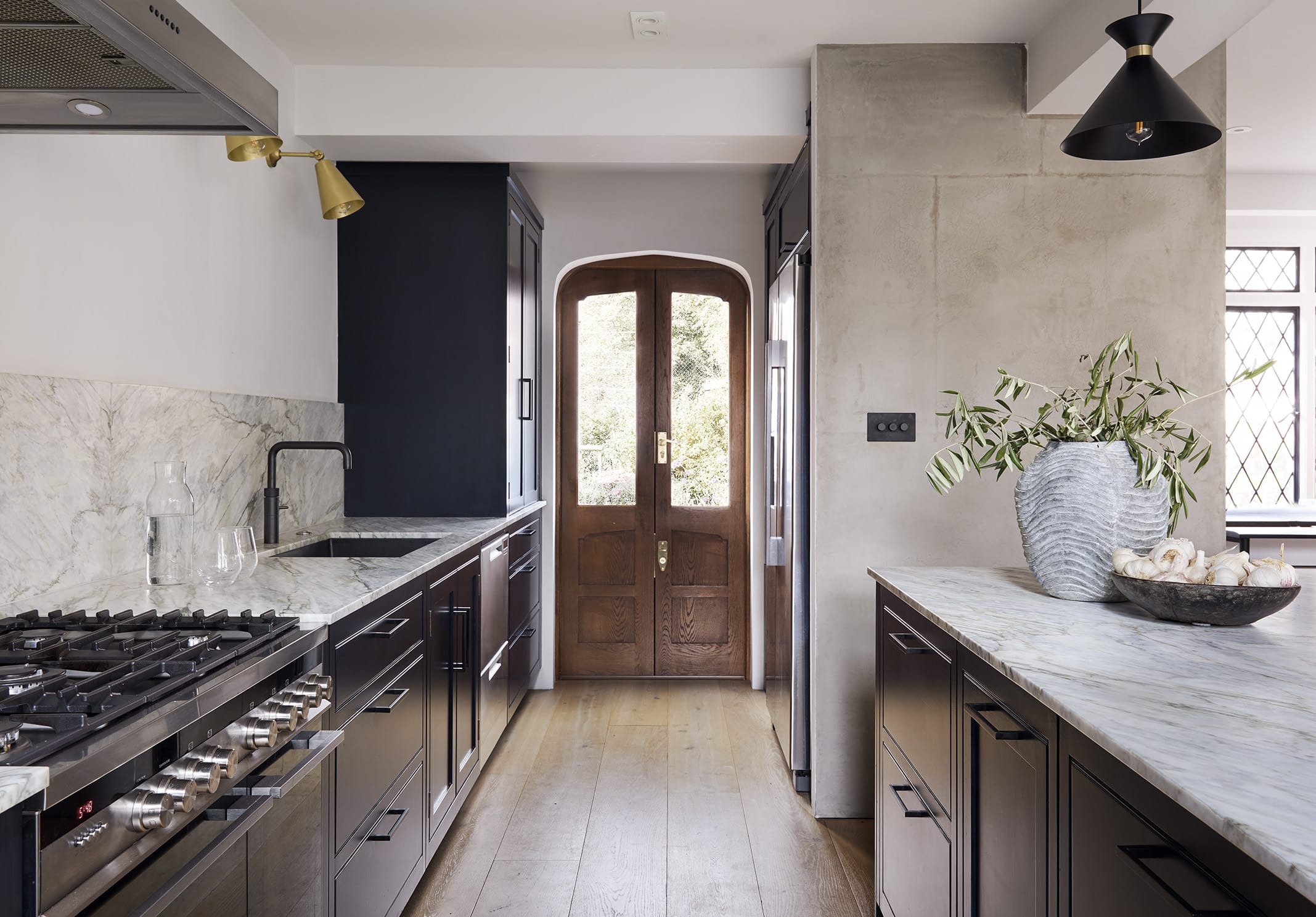 Dark Arbor kitchen cabinetry with white marble worktops and splashback