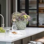 Grey Arbor kitchen island with white worktop and wooden stools