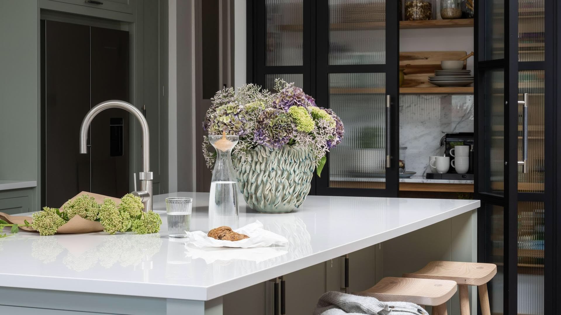 Grey Arbor kitchen island with white worktop and wooden stools