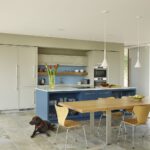 Open plan kitchen featuring blue kitchen island and dining area