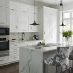 Bright white Shaker kitchen cabinetry with marble kitchen island worktop and waterfall edge