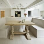 White bench seating dining area in Original design featuring a natural wooden dining table