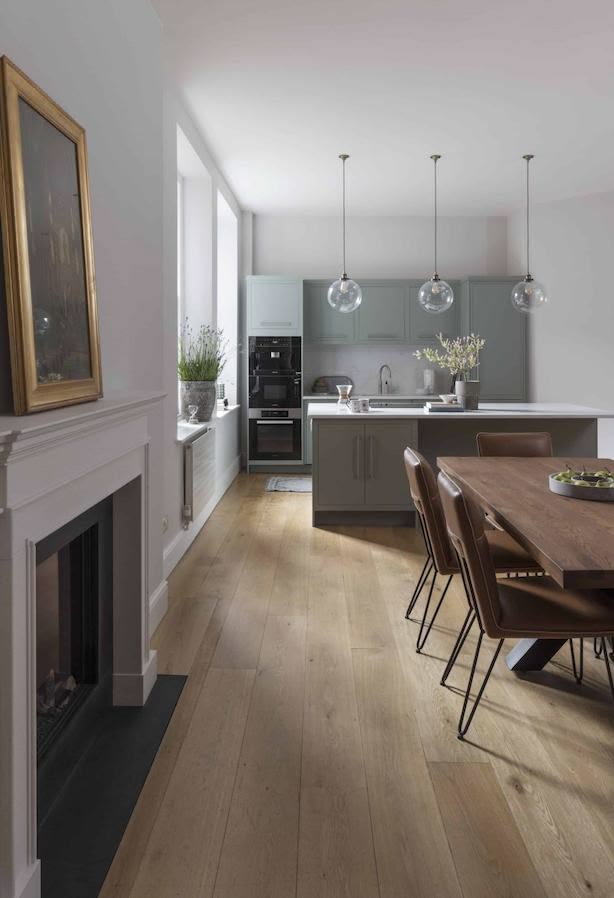 Open plan dining area overlooking a green-grey kitchen