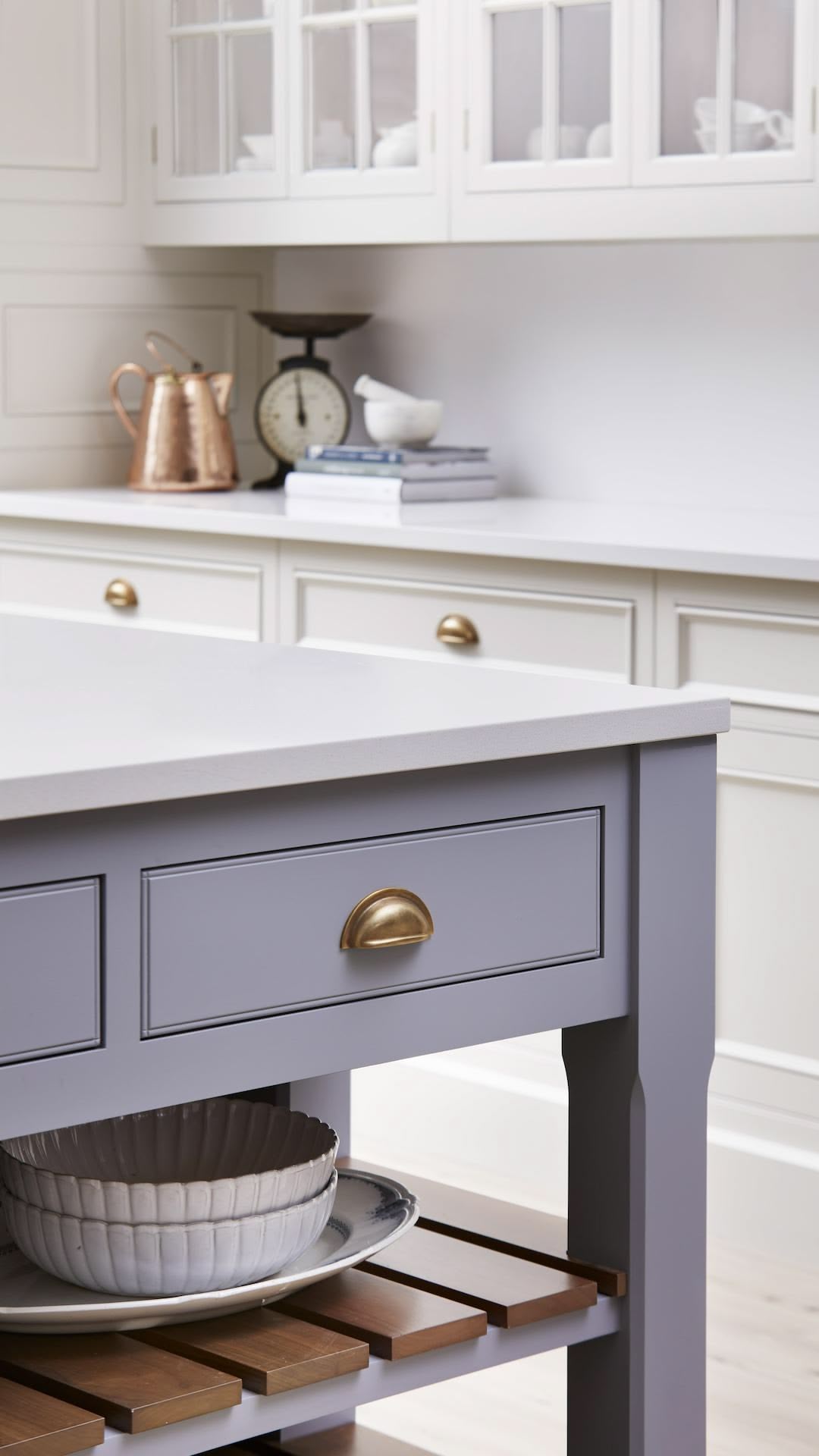 Pale blue kitchen island with drawer and brass handle with open shelving below