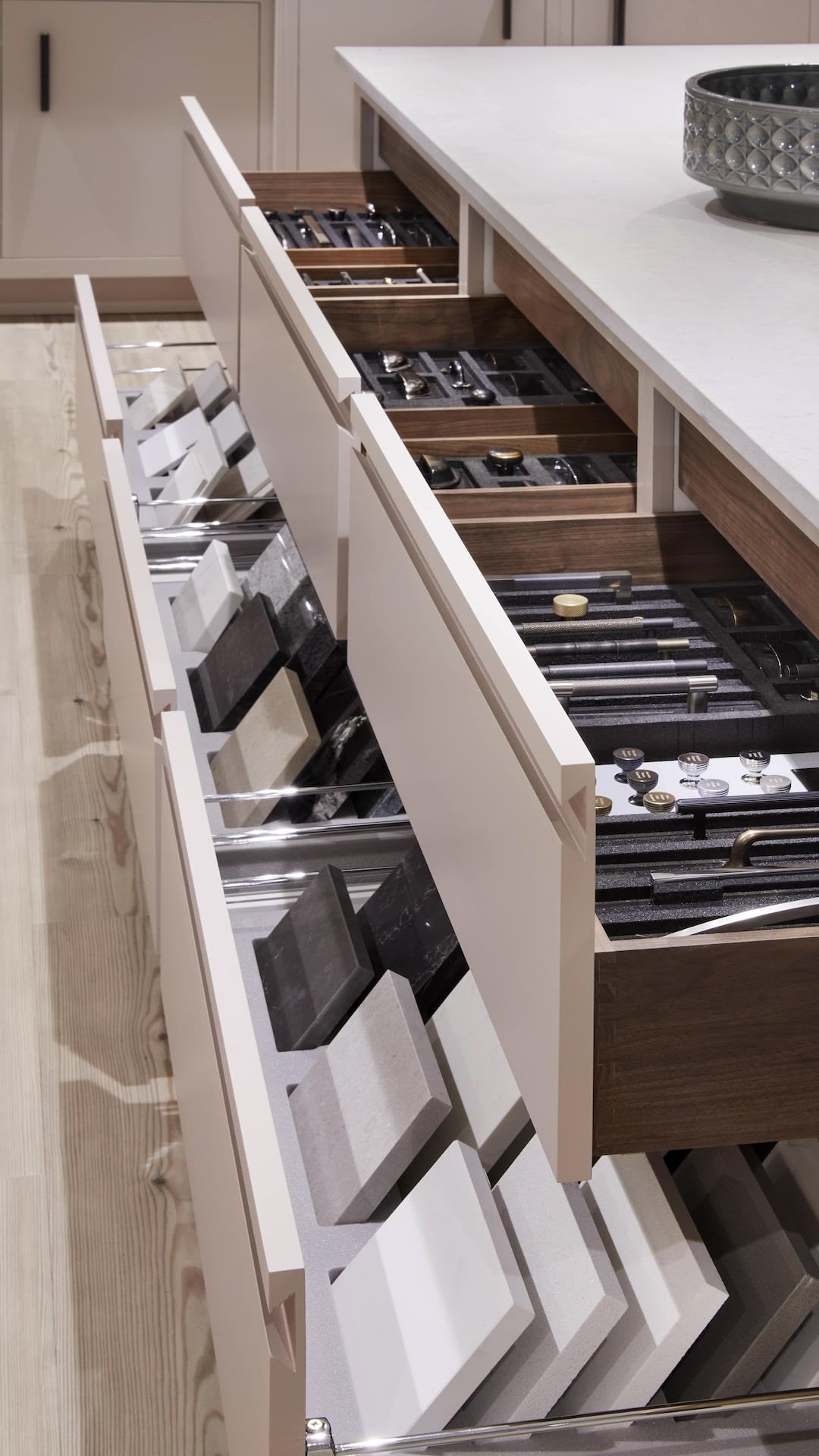 Beige kitchen drawers open to show wood colour options