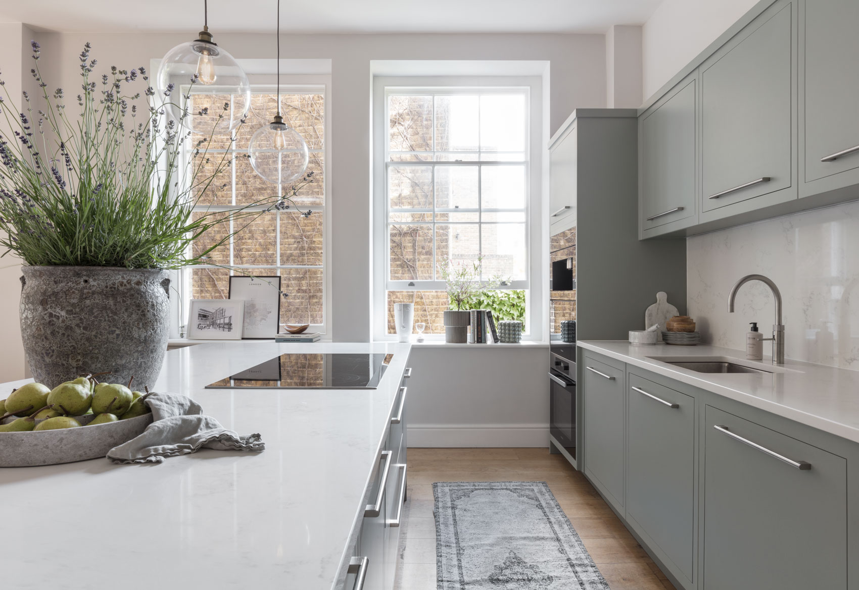 Airy light blue modern kitchen with bespoke kitchen island with hob
