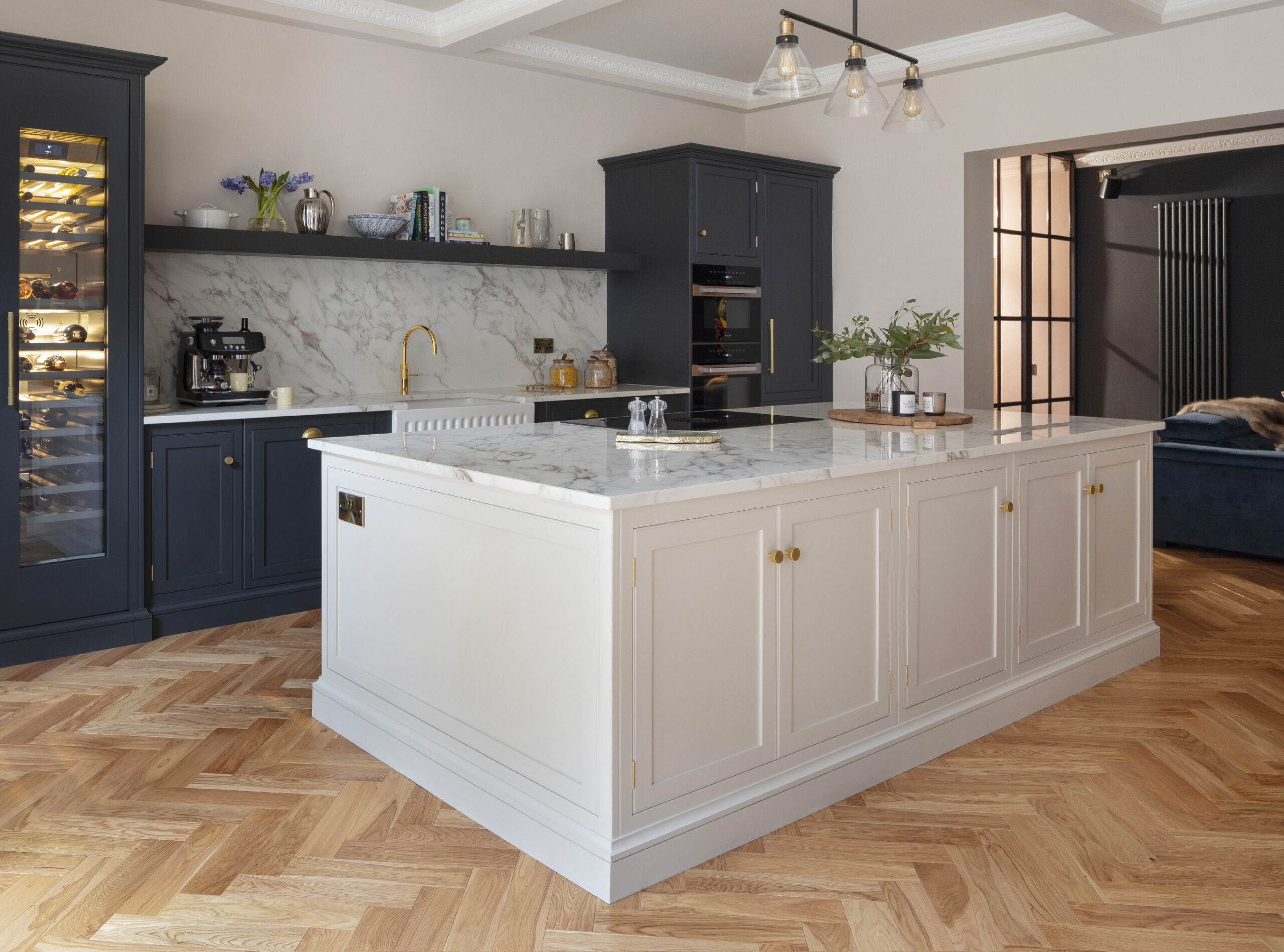Navy and white kitchen with large contrasting island with marble worktop and hidden storage