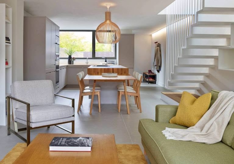 Grey kitchen cabinetry and wood kitchen island with open plan living area