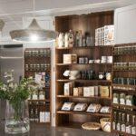 White pantry with dark wood interior open to show organised storage