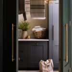 Dark utility room cabinetry seen through open door
