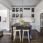 White Linear kitchen featuring statement kitchen island with dark blue cabinetry and black and brown marble worktop
