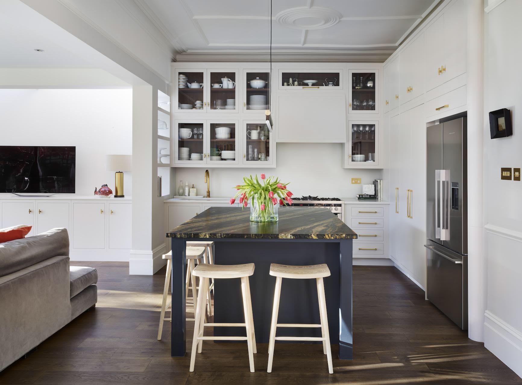 White Linear kitchen featuring statement kitchen island with dark blue cabinetry and black and brown marble worktop
