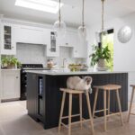 Natural wooden smile stools against a dark kitchen island