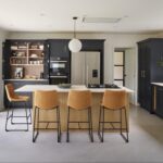 Dark Shaker kitchen cabinetry with light oak kitchen island with light grey worktops