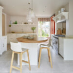 Shaker kitchen design featuring white kitchen cabinetry and orange pantry