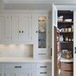 Open pantry on the end of a kitchen worktop showing organised storage and drawers