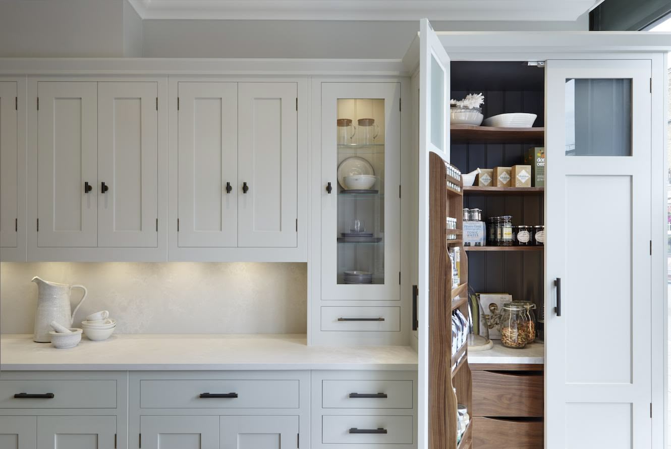 Open pantry on the end of a kitchen worktop showing organised storage and drawers