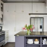 White Linear kitchen cabinetry and blue kitchen island with organised shelving