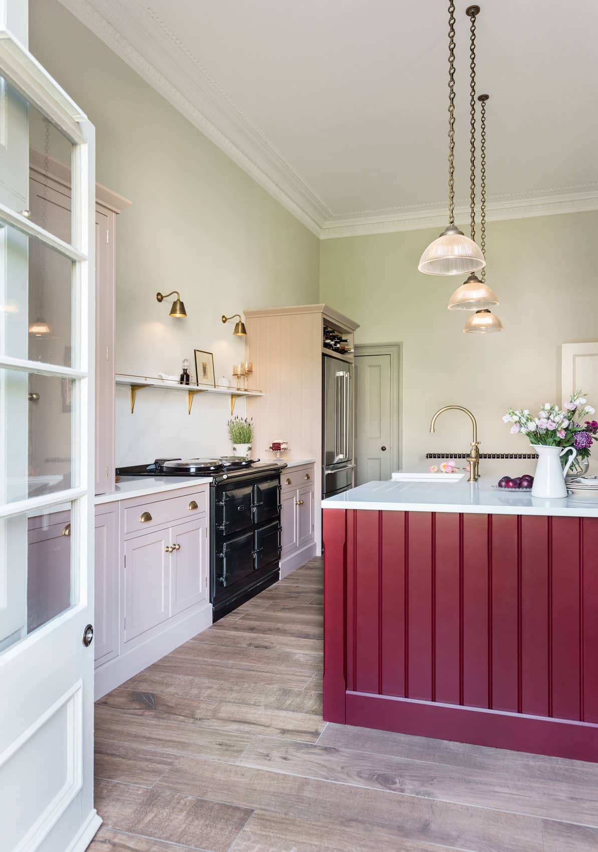 Arbor kitchen design featuring blush pink cabinetry, burgundy kitchen island with white marble worktop and dark flooring
