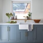 Blue Arbor kitchen cabinetry with a white basin sink and gold tap