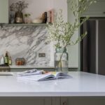 Pale green open shelving above marble splashback
