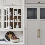 Cream Original kitchen cabinetry featuring framed glass doors revealing organised storage