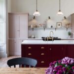 Arbor kitchen design featuring a burgundy kitchen island, blush pink cabinetry and wooden dining table