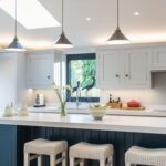 Blue Shaker kitchen island with white worktop and white bar stools