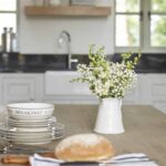Closeup of wooden kitchen island with crockery and cutlery