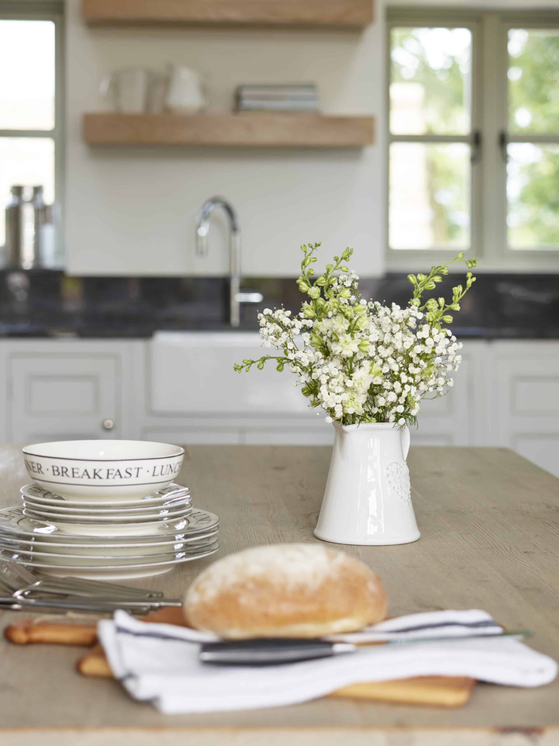 Closeup of wooden kitchen island with crockery and cutlery