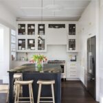 White Linear kitchen featuring statement kitchen island with dark blue cabinetry and black and brown marble worktop