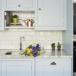 Pale blue Shaker kitchen cabinetry with white marble worktop