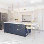 White Shaker kitchen cabinetry and blue kitchen island with white worktops