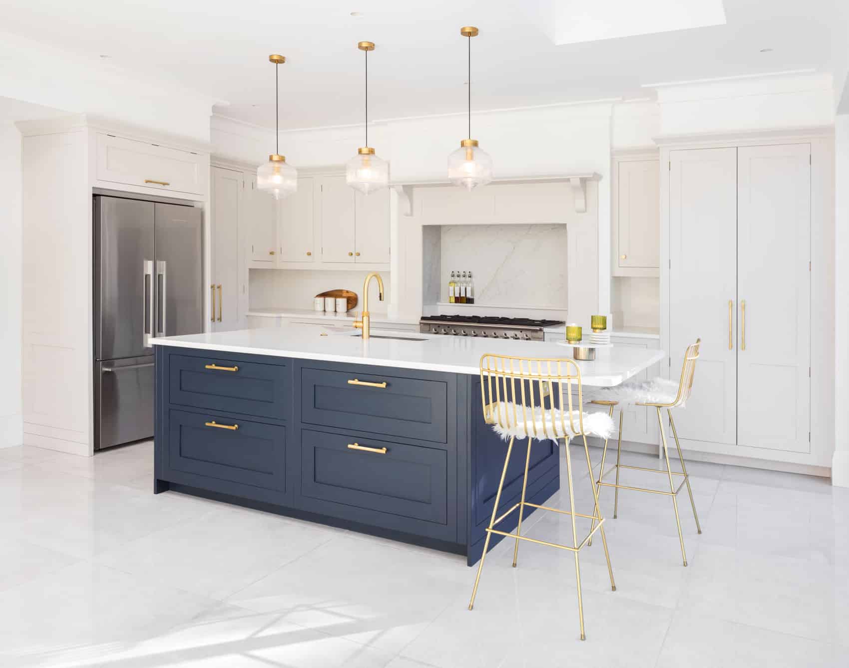 White Shaker kitchen cabinetry and blue kitchen island with white worktops
