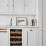 White kitchen cabinetry with oak wine rack