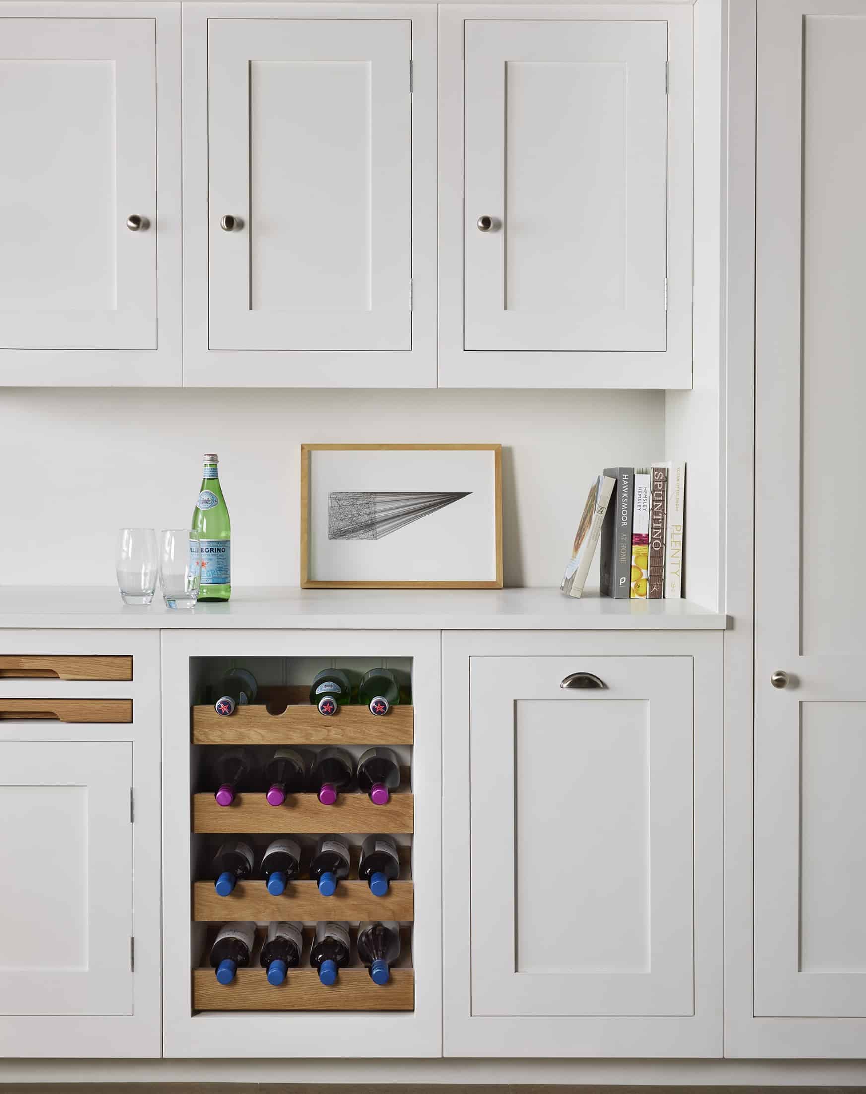 White kitchen cabinetry with oak wine rack