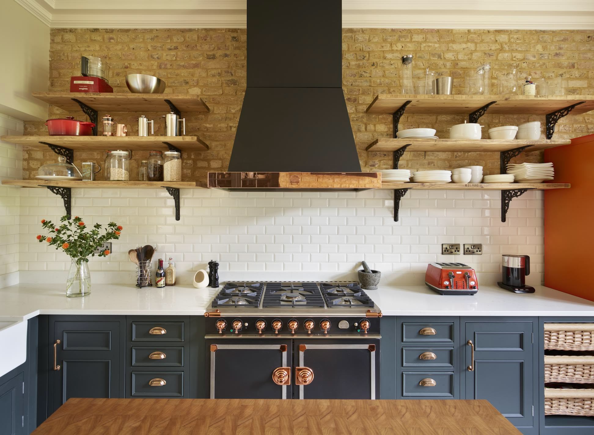 Oak open shelving against an exposed brick wall