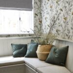 Grey corner bench seating area against a window with green cushions