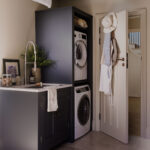 Dark utility room cabinetry featuring appliances and sink