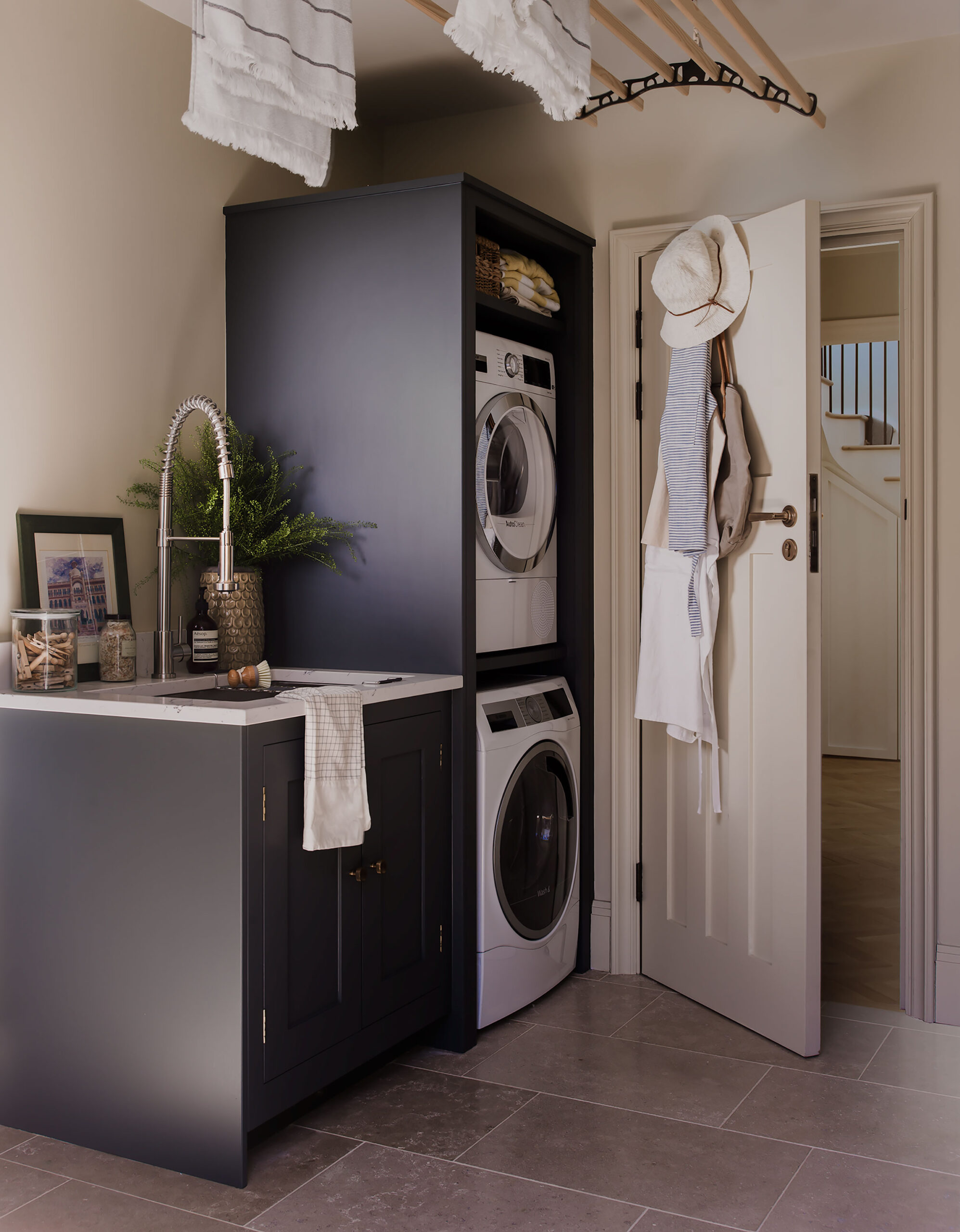 Dark utility room cabinetry featuring appliances and sink