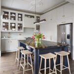 Smile stools against a deep blue kitchen island with a black and white marble worktop