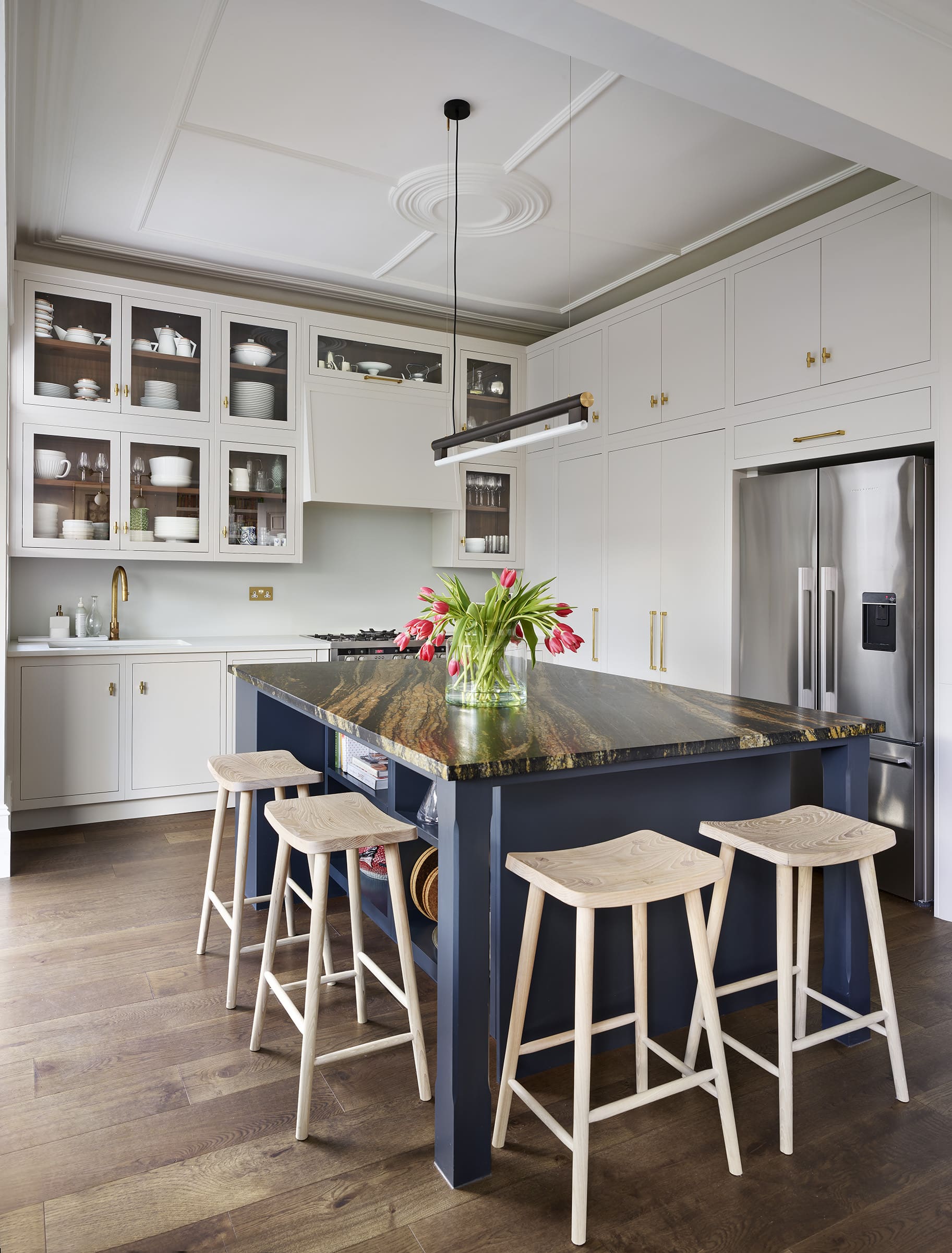 Smile stools against a deep blue kitchen island with a black and white marble worktop