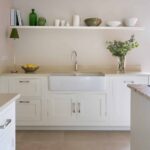 White Shaker kitchen cabinetry with cream worktop and white basin sink