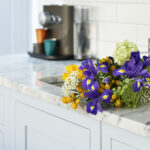 Pale blue Shaker kitchen cabinetry with white marble worktop